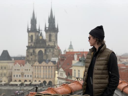 A student in Prague with a castle in the background.